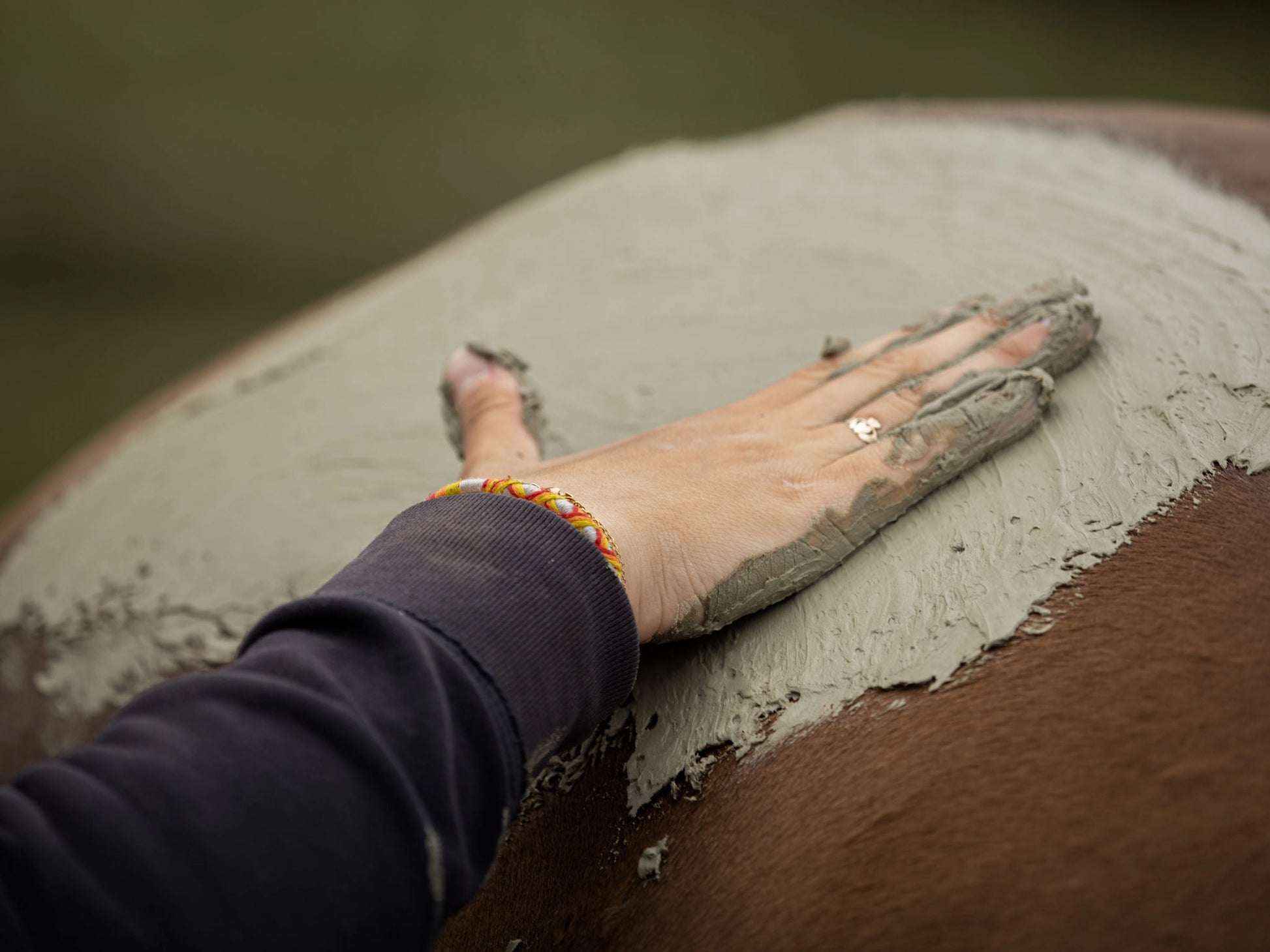 Application du cataplasme d'argile verte sur les jambes d’un cheval, pour apaiser les tensions et favoriser la récupération.